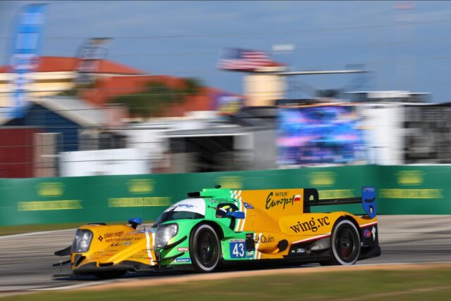 Green and yellow prototype race car number 43 speeding on a racetrack, sponsor logos visible on the body.