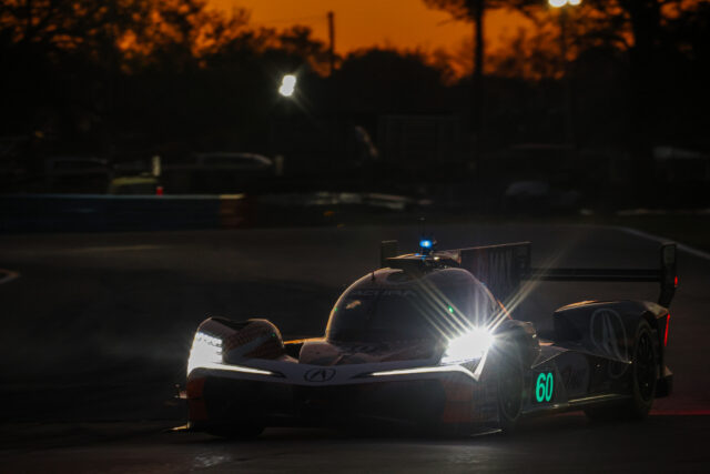 Race car on a dark track at dusk with bright headlights and the number 60 displayed in teal on the side panel.