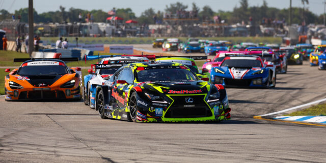 Race cars speeding on a track with a packed lineup leading the pack, front cars featuring bold neon and sponsor graphics