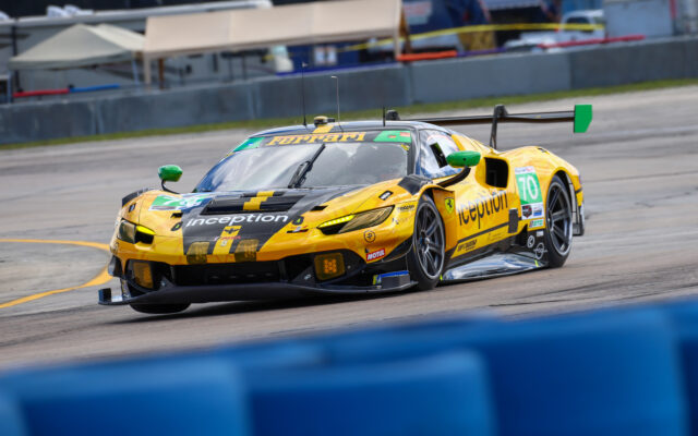 Yellow Ferrari race car with green mirrors speeds around a track, displaying number 70 and sponsor logos including Inception on the hood.